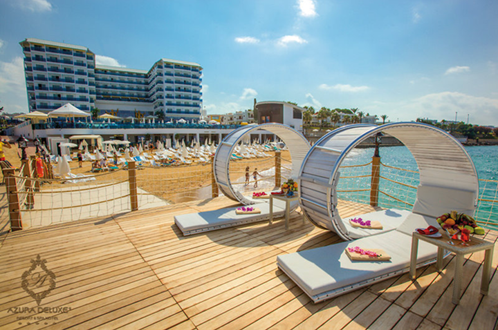 Gemütliche Holzdeck mit Liegen und Sonnenschirmen, perfekt für entspannte Stunden im Freien.