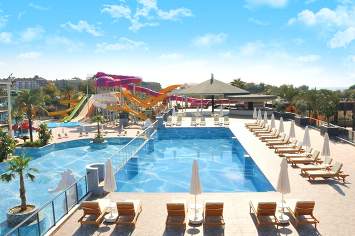Ein Hotelpool mit Sonnenliegen und aufregenden Wasserrutschen, ideal für entspannende Tage und Spaß im Wasser.