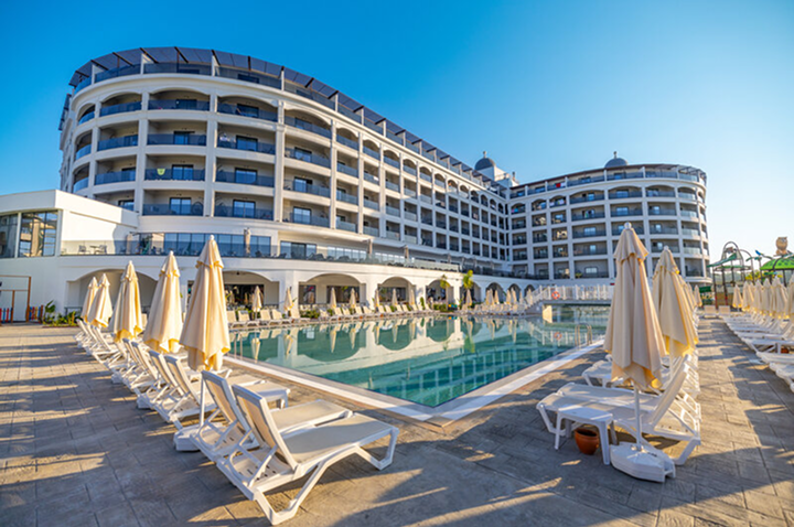 Ein modernes Hotel mit einem schönen Pool und komfortablen Liegen, ideal für Erholung und Entspannung.