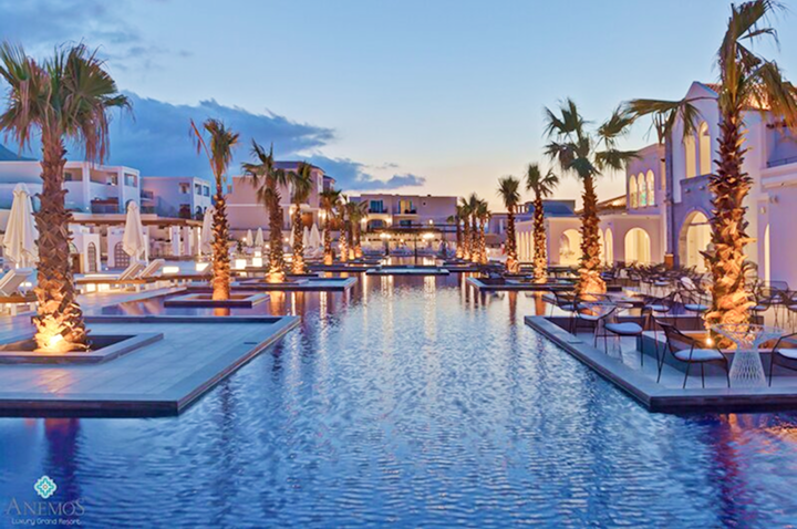 Großer Pool mit beleuchteten Palmen und Liegestühlen in einem luxuriösen Hotelkomplex bei Dämmerung. Großer Pool mit beleuchteten Palmen und Liegestühlen in einem luxuriösen Hotelkomplex bei Dämmerung.