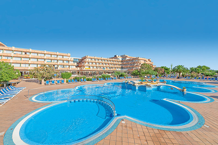 Großer Hotelpool mit bequemen Liegen und Sonnenbetten, ideal zum Entspannen und Sonne tanken.