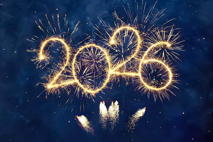 Feuerwerk in der Nacht formt die Zahlen '2026' mit goldenen Funken und weiteren bunten Feuerwerkskörpern im Hintergrund.