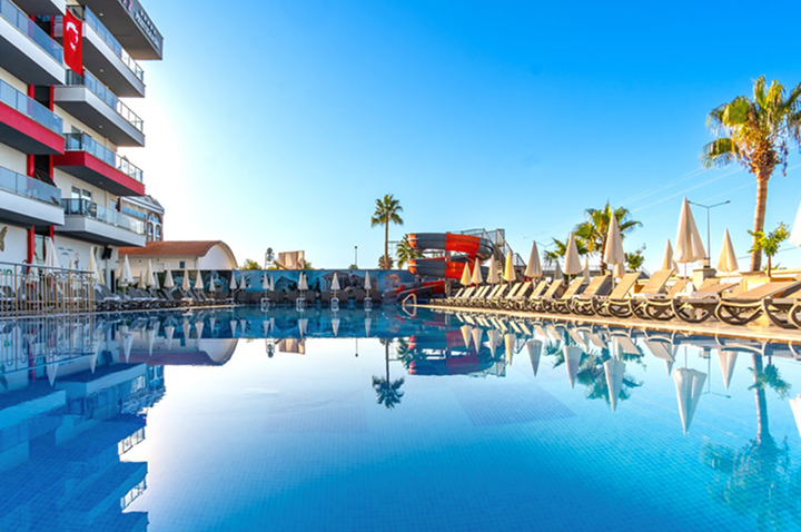 Entspannender Poolbereich mit Liegen und Schirmen vor einem Hotel, perfekt für einen sonnigen Tag. Entspannender Poolbereich mit Liegen und Schirmen vor einem Hotel, perfekt für einen sonnigen Tag.