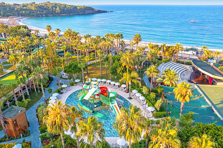 Luftaufnahme des Strandes und Resorts mit Wasserrutschen, die lebhafte Farben und entspannte Urlaubsatmosphäre zeigen. Luftaufnahme des Strandes und Resorts mit Wasserrutschen, die lebhafte Farben und entspannte Urlaubsatmosphäre zeigen.