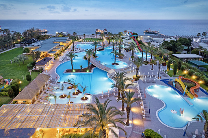 Nachtsicht auf den Hotelpool und den Strand, romantisch beleuchtet und ruhig unter dem nächtlichen Himmel. Nachtsicht auf den Hotelpool und den Strand, romantisch beleuchtet und ruhig unter dem nächtlichen Himmel.