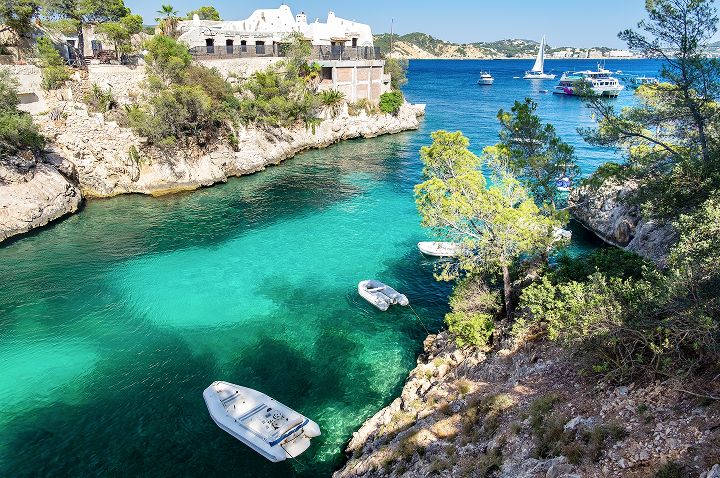 Eine Gruppe von Booten schwimmt im Wasser nahe einer felsigen Küste, umgeben von sanften Wellen und klarem Himmel. Eine Gruppe von Booten schwimmt im Wasser nahe einer felsigen Küste, umgeben von sanften Wellen und klarem Himmel.